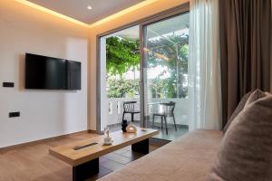 a living room with a couch and a tv and a table at Paul Marie in Hersonissos