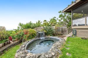 a small pond with a fountain in a yard at Koana Oasis in Kailua-Kona