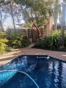a swimming pool in front of a house at Giardino a 194 in Welkom