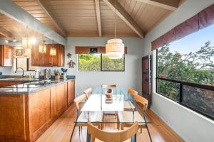 a dining room with a table and chairs in a kitchen at Koana Oasis in Kailua-Kona