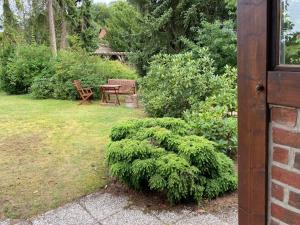 um jardim com uma mesa, um banco e um arbusto em Ferienwohnung Neetze em Neetze