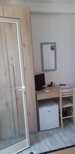 Habitación con escritorio, ordenador, escritorio y puerta. en Affittacamere Da Antonella, en Posada