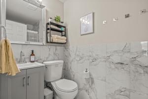 Baño blanco con aseo y lavamanos en Uptown Gem! 2Luxe King Suites - 5 Smart TV's - Parking en Filadelfia