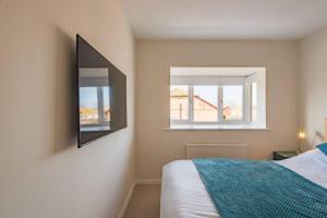 a bedroom with a bed and a mirror on the wall at Links Bay - 100 yards from beach and golf course in Deal