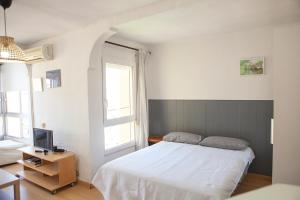 Schlafzimmer mit einem weißen Bett und einem TV in der Unterkunft Apartment with see view in Algarrobo-Costa