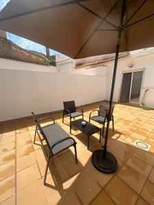 un grupo de sillas y una sombrilla en un patio en Flat 'Hoces del Cabriel' in Casas de Moya, 