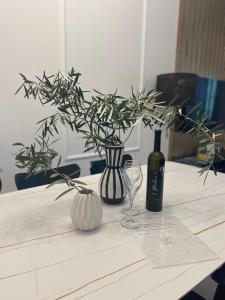 a table with a vase and a bottle of wine at Rosetta Suite in Novi Vinodolski