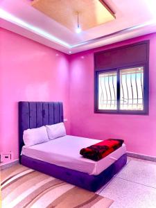 1 dormitorio rosa con 1 cama en una habitación en Résidence Othmane en Dakhla