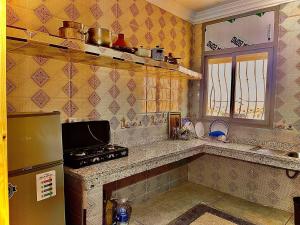 a kitchen with a refrigerator and a counter top at Résidence Othmane in Dakhla