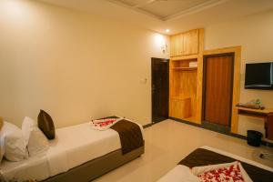Habitación de hotel con cama y TV en TPC Camphor en Tiruchchirāppalli