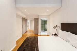 a white bedroom with a large bed and a hallway at Ultra Luxury 3 Bedroom Address on Adderley in Cape Town