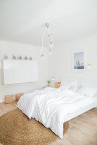 een witte slaapkamer met een groot bed met witte lakens bij Chalupa Morava in Veselí nad Moravou