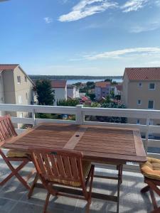 a wooden table and chairs on a balcony at Apartments Olea in Rab