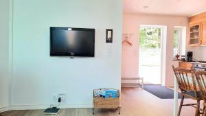 een woonkamer met een flatscreen-tv aan de muur bij Boende - Stuga nära naturen, 3 km från Motala centrum av privat värd in Motala