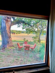 - une vue sur une table et des chaises depuis la fenêtre dans l'établissement La cabane de babarot, à Aups