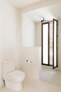 uma casa de banho branca com um WC e uma janela em Villa catalina Bora 2 Resort em Nabas