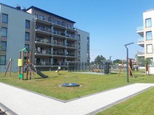 a playground in front of a apartment building at Apartamenty BEST HOME & SPA basen kryty in Ustronie Morskie
