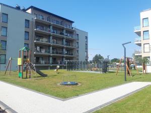 a playground in front of a apartment building at Apartamenty BEST HOME & SPA in Ustronie Morskie