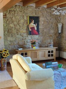 uma sala de estar com um sofá e uma pintura numa parede de pedra em B&B QUINTARELLI em San Pietro in Cariano