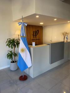 a lobby with a counter with a blue and white flag at Hotel Plaza in Coronel Suárez