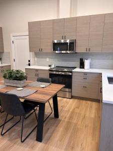a kitchen with a wooden table and a kitchen with a stove at Cozy and Adorable Tiny House - Near PDX! in Vancouver