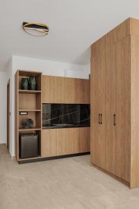 una cocina con armarios de madera y una lámpara. en Cens Gold Luxury Suites, en Ioannina