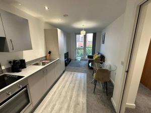 a kitchen with a sink and a table in a room at Cosy MCR 1 Bed Apt with Balcony in Manchester