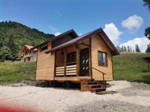 a tiny house sitting on top of a gravel lot at Cazare la Vama Buzăului - Căsuța Festung in Vama Buzăului