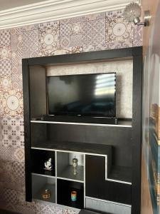 a flat screen tv sitting on top of a fireplace at Calm Apartment in Mazola next to Aeria Mall & Casa Finance City in Casablanca