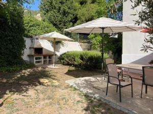 a patio with tables and umbrellas in a yard at Alfapinoalegre in Alfacar