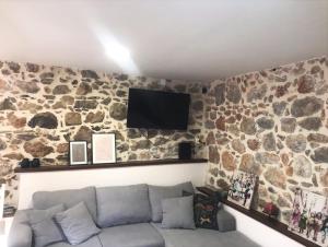 a living room with a stone wall with a couch at METAXIAS HOUSE in Leonidio