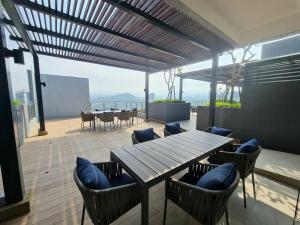 un patio con tavolo e sedie in legno e l'oceano di Contemporary 2R2B Studio 10 minutes from KLCC a Kuala Lumpur