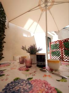 un tavolo con un ombrello bianco e alcune ciotole di Casa Vacanze La Coccinella a Trapani