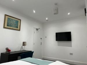 a bedroom with a bed and a tv on the wall at Inviting 2-Bed Apartment in Ilford in Ilford