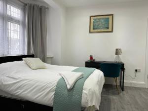 a bedroom with a bed and a desk and a chair at Inviting 2-Bed Apartment in Ilford in Ilford