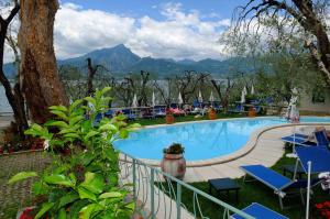 a swimming pool with chairs and a view of the mountains at Hotel Internazionale in Torri del Benaco