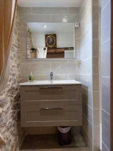 W łazience znajduje się umywalka i lustro. w obiekcie Le Logis des Remparts Coeur de la Cité médiévale w Carcassonne