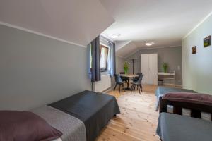 a bedroom with two beds and a table with chairs at Górskie Klimaty in Kletno