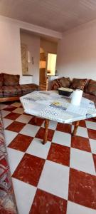 a living room with a table and a checkered floor at 06ber26kane82 en face 96 carrefour06 in Berkane