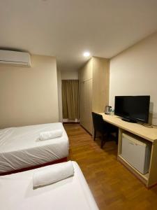 a hotel room with a bed and a desk with a computer at Hotel Ambassador @ Bukit Bintang in Kuala Lumpur