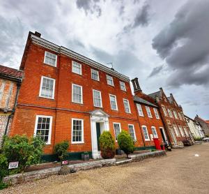 um grande edifício de tijolos vermelhos com janelas brancas em Elmham House - Pilgrim Hotel em Little Walsingham
