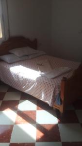 a bedroom with a bed with a checkered floor at 06ber26kane82 en face 96 carrefour06 in Berkane