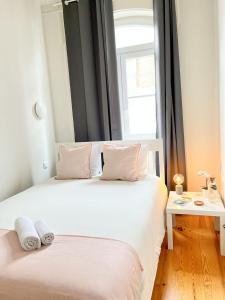 1 dormitorio con 1 cama blanca y ventana en Cozy room with privative bathroom on Rua Augusta, en Lisboa
