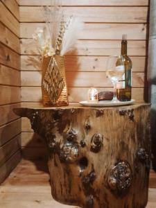 a table made out of a tree stump with a glass of wine at The Cottage Angochagua in Ibarra