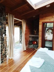 ein Schlafzimmer mit einem Kamin und einem Bett in einem Zimmer in der Unterkunft The Cottage Angochagua in Ibarra