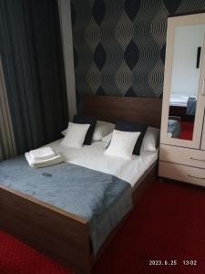 a bedroom with a bed with white pillows and a mirror at Lusia in Wisła