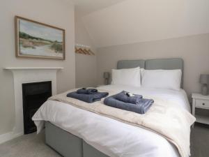 a bedroom with a bed with two towels on it at 2 Golf Links Cottages in Northwich