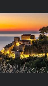 una casa en una colina con la puesta de sol en el fondo en Zanna Casa Vacanza en Grottammare