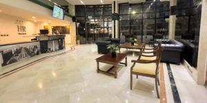 a lobby with couches and a table and chairs at Hotel HR Plaza Luxor in Buenos Aires