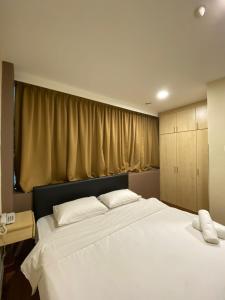 a large white bed in a room with a window at Hotel Ambassador @ Bukit Bintang in Kuala Lumpur